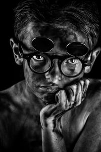 Close-up portrait of shirtless boy wearing eyeglasses