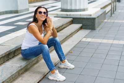 Portrait of young woman sitting in sunglasses