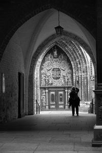 Rear view of man walking in corridor of building