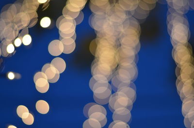 Low angle view of illuminated lights against sky at night