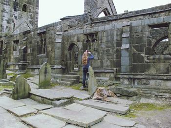 Rear view of woman photographing at heptonstall museum