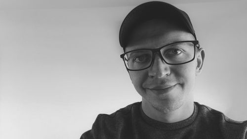 Portrait of young man wearing eyeglasses against white background