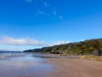 Scenic view of beach against blue sky