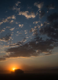 Sun shining through clouds at sunset