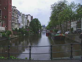 Boats moored in city against sky
