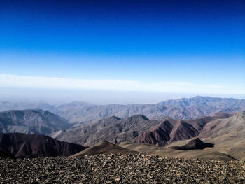 Scenic view of mountains against blue sky