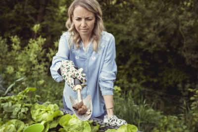 Full length of woman holding flowering plants