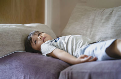 Cute boy resting on bed at home