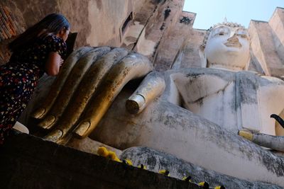 Low angle view of woman praying in temple