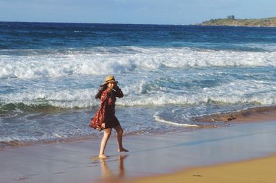 Full length of woman standing on beach