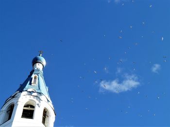 Low angle view of bell tower against blue sky