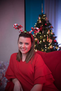 Portrait of smiling young woman wearing christmas tree