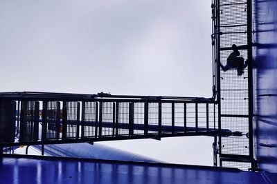 Metallic structure by sea against clear sky