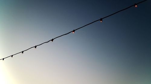 Low angle view of barbed wire against clear sky