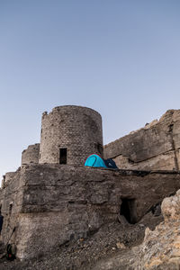 Low angle view of castle sitting against clear blue sky