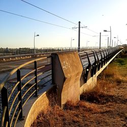 Train bridge on field against clear sky