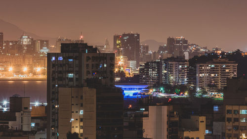 Illuminated buildings in city against sky at night