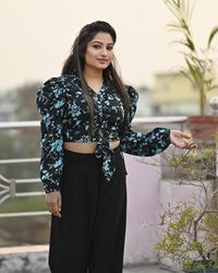 Portrait of young woman standing against wall