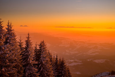 Scenic view of mountains against orange sky