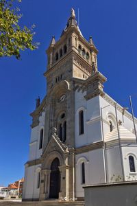 Low angle view of bell tower against blue sky