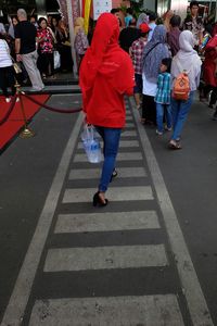 Full length of woman sitting on railing