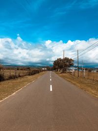 Road passing through landscape against blue sky