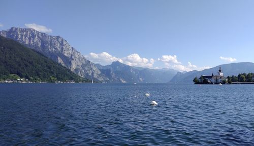 Scenic view of sea and mountains against sky