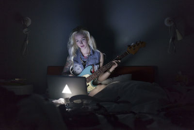 Beautiful young woman playing an electric guitar