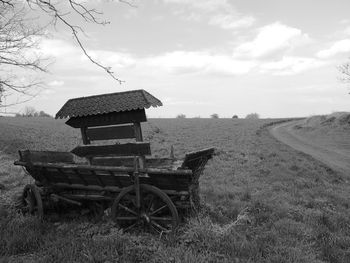 Shopping cart on farm against sky