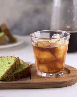 Close-up of iced tea in glass by breads on table