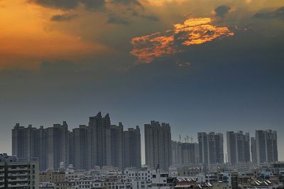 Skyscrapers in city at sunset