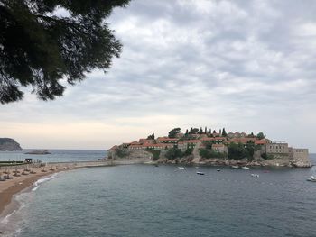 Scenic view of sea by buildings against sky