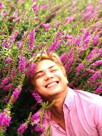 Portrait of smiling young woman against pink flowering plants