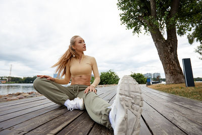 Portrait of woman sitting on boardwalk