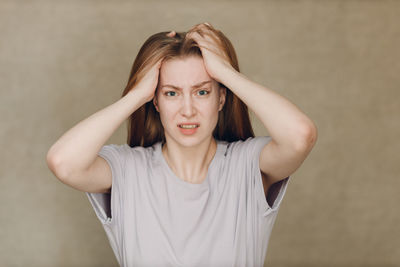 Portrait of young woman looking away against wall