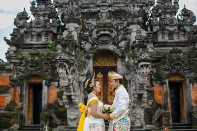 Full length of man standing in temple outside building