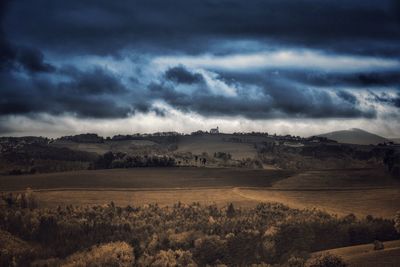 Scenic view of landscape against storm clouds