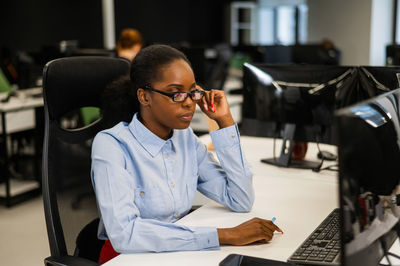 Portrait of an african young woman at a desk in the office