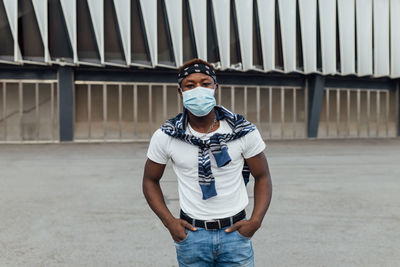 Portrait of young man standing against wall