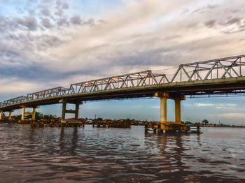 Low angle view of bridge over river against sky