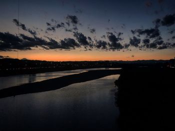 Scenic view of river against sky at sunset