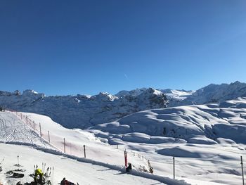 Scenic view of snowcapped mountains against clear blue sky