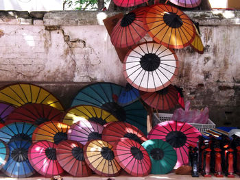 Umbrellas on display by wall