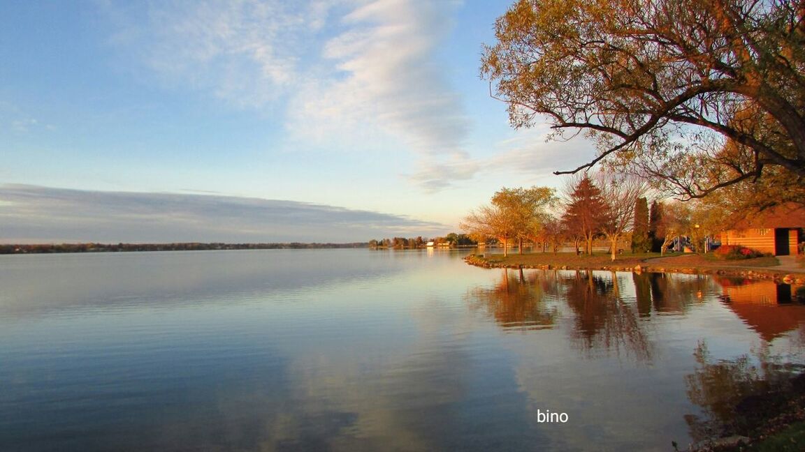 water, reflection, sky, scenics, tranquility, beauty in nature, tranquil scene, cloud - sky, built structure, nature, tree, waterfront, lake, outdoors, architecture, no people, building exterior, day, sunset, mountain