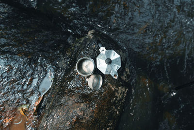 Directly above shot of containers on rock in river