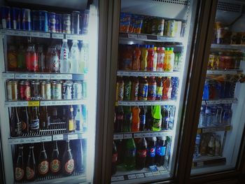 Multi colored bottles in shelf at market stall