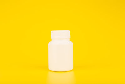 Close-up of bottle against yellow background
