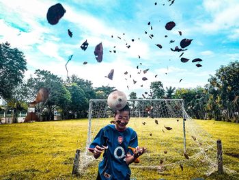 Full length of boy flying kite against sky