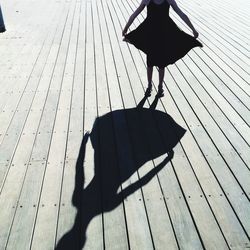 Low section of girl standing on floorboard