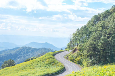 Scenic view of road by mountains against sky